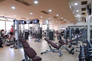 Fitnesscenter im Cactus Royal Hotel mit verschiedenen Trainingsgeräten und Spiegeln.