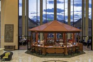 Lobby des Princess Inspire Tenerife Hotels mit Pavillon und Bar, umgeben von Säulen und Möbeln.