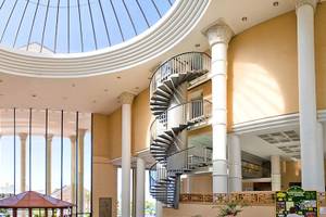 Innenansicht des Princess Inspire Tenerife Hotels mit zwei spiralförmigen Treppen und einer Glaskuppel.