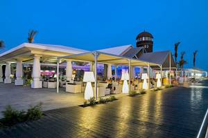 Außenbereich des Barcelo Fuerteventura Castillo Hotels bei Nacht mit Beleuchtung und Gästen.