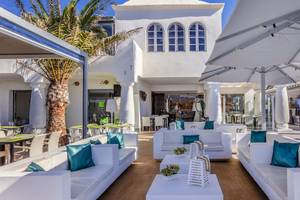 Außenbereich des Barcelo Fuerteventura Castillo Hotels mit weißen Sofas, Tischen und Palmen