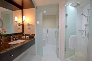 Badezimmer im Intercontinental Hotel in Abu Dhabi mit Glasdusche, Waschbecken und Spiegel.