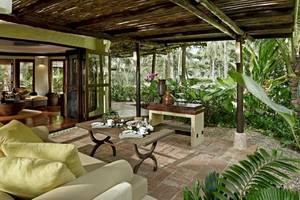 Gartensitzbereich des Rayavadee Hotels mit Tisch, Stühlen und Pflanzen.