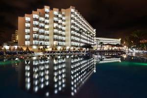 Alexandre Hotel Troya bei Nacht mit Pool und Hotelbeleuchtung.