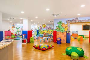 Kinderspielzimmer im Alexandre Hotel Troya mit bunten Möbeln und Wandmalereien.