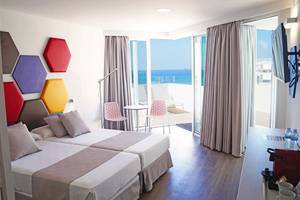 Doppelzimmer im Alexandre Hotel Troya mit Blick auf das Meer von einem Balkon aus.