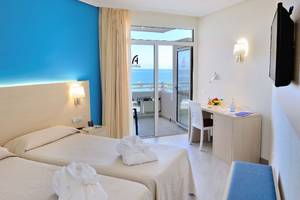 Doppelzimmer im Alexandre Hotel Troya mit Meerblick, zwei Betten, Schreibtisch und Balkon.