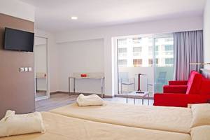 Doppelzimmer im Alexandre Hotel Troya mit Blick auf den Balkon und das Zimmerinterieur.