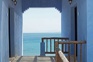 Balkon des Candia Park Village mit Blick auf das Meer und blau gestrichenen Wänden.