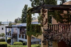 Aussenbereich des Candia Park Village Hotels mit Gebäuden, Terrassen und Bepflanzung.