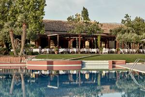 Außenansicht des Candia Park Village Hotels mit Swimmingpool und bewirtetem Restaurant.