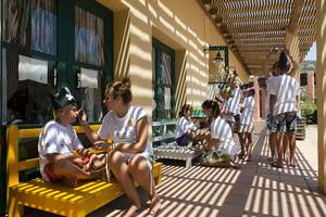 Kinderanimation im Candia Park Village mit einem Jungen, der eine Piratinnenmütze trägt, während eine Frau ihm die Wange streichelt.