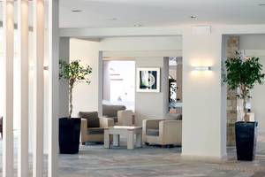 Lobby des Porto Bello Beach Hotels mit Möbeln und Pflanzen.
