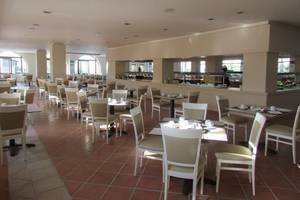 Frühstücksraum des Porto Bello Beach Hotels mit vielen Tischen und Stühlen.