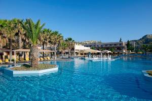 Außenpool des Porto Bello Beach Hotels mit Palmen und Sonnenliegen