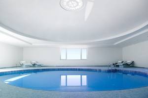 Innenpool des Elounda Village Resort & Spa mit weißen Wänden und blauem Wasser