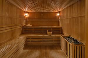 Innenansicht der Sauna im Elounda Village Resort & Spa mit Holzwänden und Bänken.