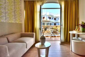 Wohnzimmer mit Sofa und Balkon im Kalyves Beach Hotel.