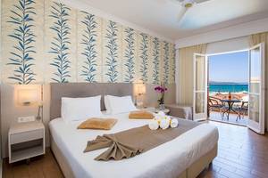 Schlafzimmer im Kalyves Beach Hotel mit Blick auf den Balkon und das Meer