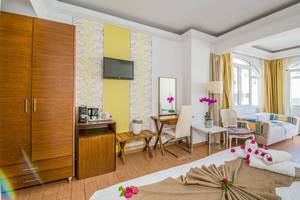 Innenansicht eines Zimmers im Kalyves Beach Hotel mit Bett, Schreibtisch, Fernseher und Möbeln.