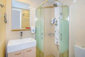 Badezimmer im Kalyves Beach Hotel mit Dusche, Spiegel und Waschbecken.
