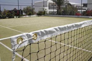 Tennisplatz im Hersonissos Maris Hotel, umgeben von Gebäuden und Pflanzen.