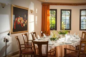 Ein formelles Esszimmer im Hersonissos Maris Hotel mit Tisch, Stühlen und Dekor.