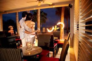 Paar auf der Terrasse des Riu Palace Peninsula Hotels, das eine Feuershow beobachtet