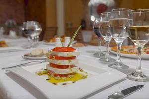 Gericht auf einem Teller im Hotel Melia Las Antillas mit Tomaten, Käse und Öl.