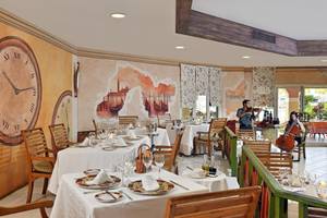 Innenansicht des Restaurants im Melia Las Antillas Hotel mit Tisch, Uhr und Musikern.