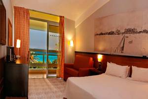Hotelzimmer im Occidental Arenas Blancas mit Blick auf das Meer und einem großen Wandbild.