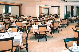 Innenansicht des Restaurants im Calypso Palace Hotel mit gedeckten Tischen und Stühlen.
