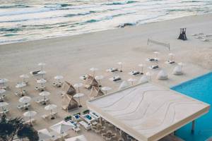 Luftaufnahme des Coral Level at Iberostar Selection Cancun Strand mit Pool und Sonnenliegen.