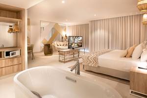 Schlafzimmer im Guayarmina Princess Hotel mit Bett, Fernseher, Badewanne und Möbeln.