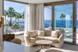 Wohnzimmer im Guayarmina Princess Hotel mit großer Fensterfront und Meerblick.