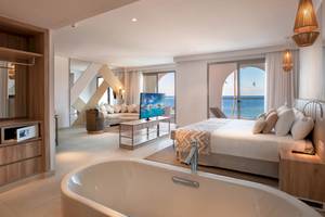 Suite im Guayarmina Princess Hotel mit Blick auf das Meer und ein modernes Interieur.