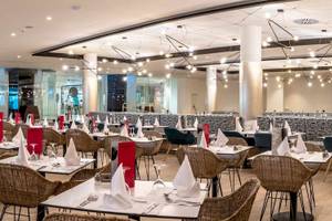Restaurant im Guayarmina Princess Hotel mit gedeckten Tischen und Stühlen.