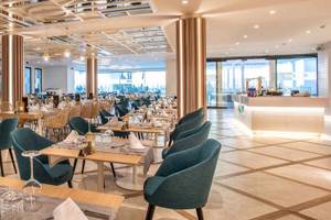 Innenansicht des Restaurants im Guayarmina Princess Hotel mit modernen Möbeln und großen Fenstern.