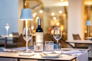 Tisch im Restaurant des Guayarmina Princess Hotels, eingerichtet mit Weinflasche, Gläsern und Besteck.