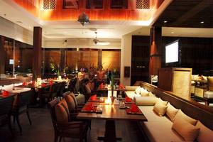 Innenbereich des Restaurants im Mai Samui Beach Resort & Spa mit gedeckten Tischen und stehenden Gästen.