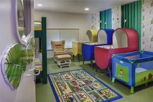 Kinderzimmer im Maxx Royal Belek Golf Resort mit bunten Kinderbetten und einem Teppich.