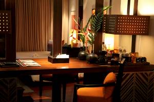 Hotelzimmer mit Schreibtisch, Kissen und Pflanzendekor