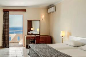 Zimmer im Mitsis Family Village Beach Hotel mit Blick auf das Meer und eine Terrasse.