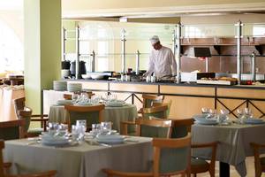 Restaurant im Mitsis Family Village Beach Hotel mit Chefkoch hinter der Theke.