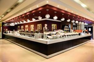 Buffetbereich im Al Hamra Residence Hotel mit vielen Speisen und Geschirr.