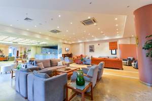 Innenbereich des Mediterranean Beach Resort in Zakynthos mit Sofas, Tischen und Pflanzen.