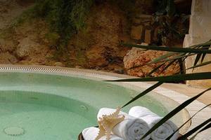 Jacuzzi im Freien mit Pflanzen im Hintergrund im Coral Beach Hotel & Resorts
