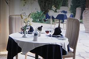 Innenansicht des Restaurants im Coral Beach Hotel mit Tisch, Stühlen und großen Vasen.