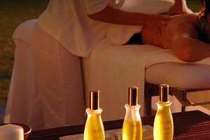 Frau genießt Massage im Freien im Coral Beach Hotel & Resorts
