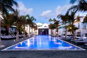 Außenpoolbereich des Barceló Teguise Beach Adults Only Hotel mit Lounge-Stühlen und Palmen